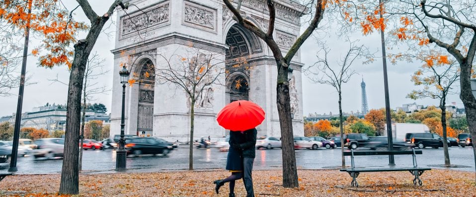 Couple sous un parapluie à l'Arc de Triomphe