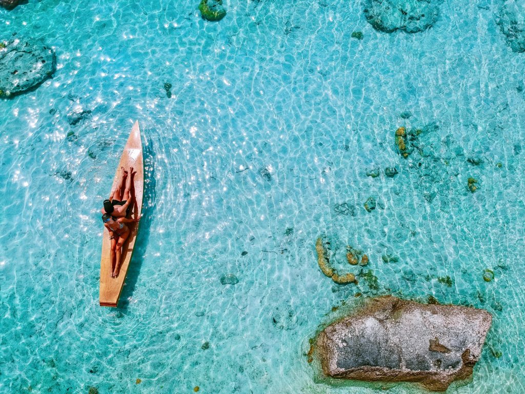 couple sur une planche baignant dans des eaux turquoise