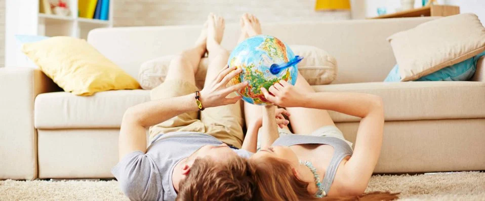 Deux personnes tenant un globe terrestre, allongées par terre