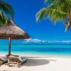 Chairs and umbrella at palm beach. Tropical holiday banner with ocean in Mauritius