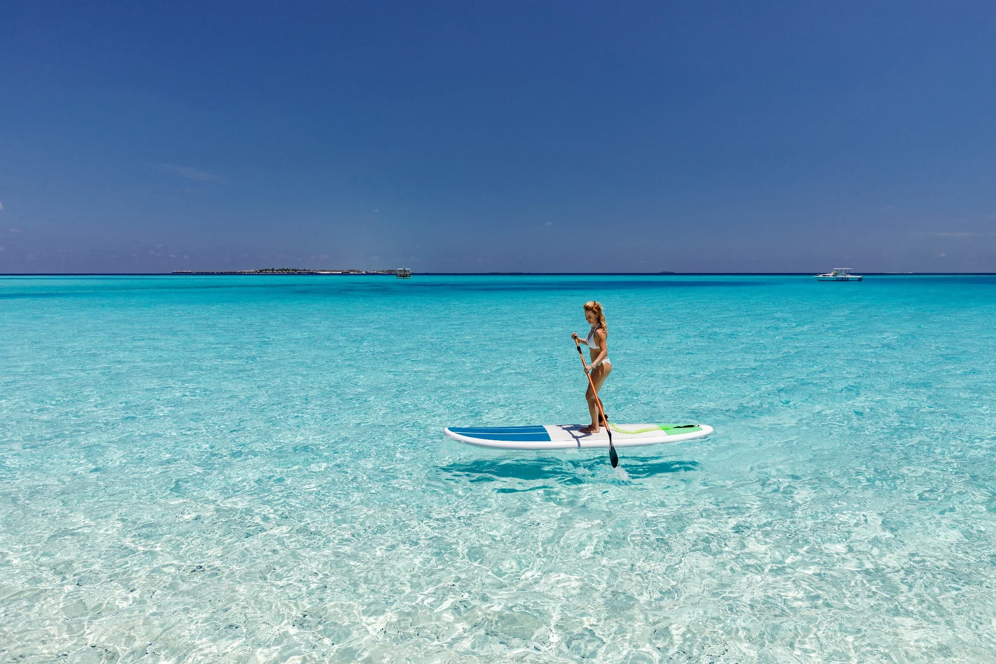 Jeune femme en paddle sur le lagon cristallin des Maldives