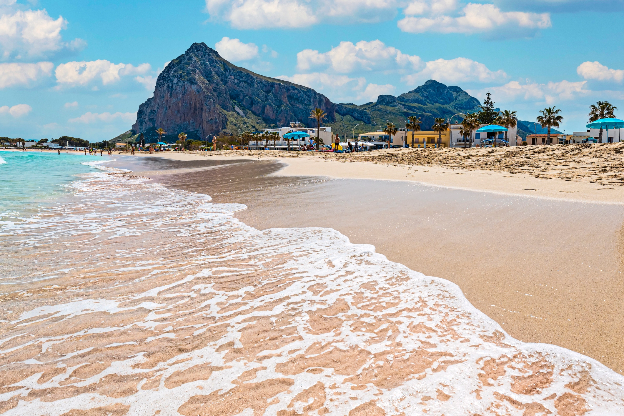 Plage de San Vito Lo Capo en Sicile, sable clair et mer turquoise au pied d’une falaise rocheuse