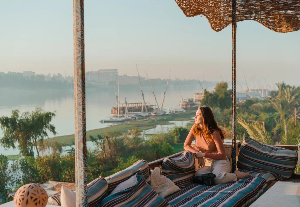 Femme profitant d’une terrasse avec vue sur le Nil en Égypte, atmosphère calme et ensoleillée