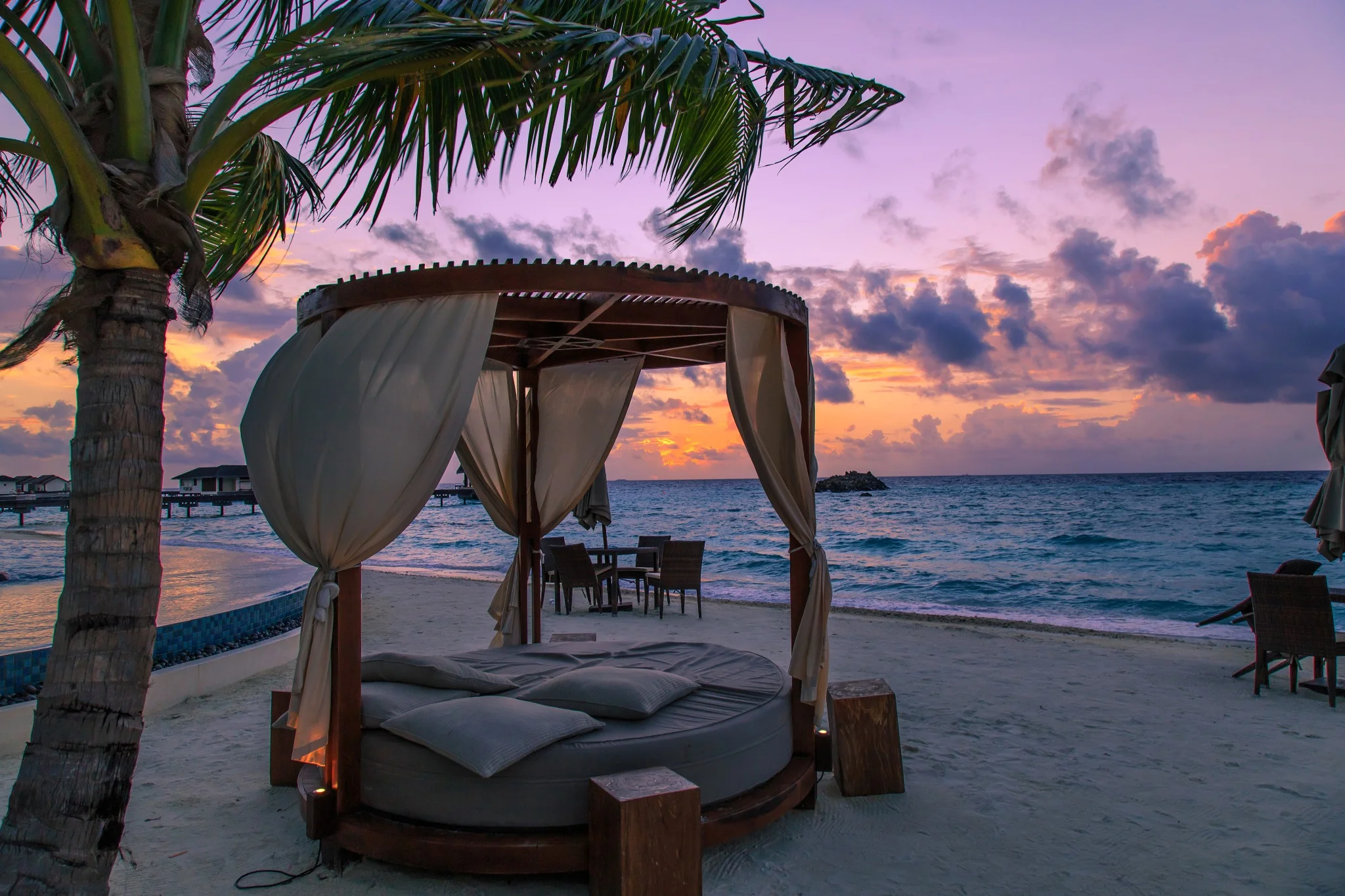 Villa de luxe sur la plage aux Maldives au coucher du soleil, idéale pour un séjour de plusieurs jours