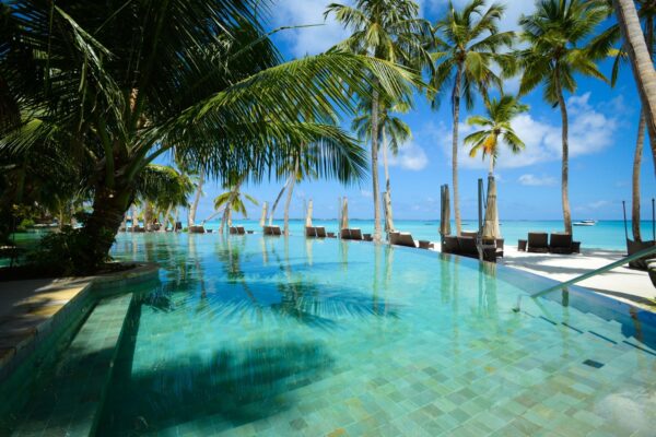 Resort luxe à l’île Maurice avec piscine bordée de palmiers face au lagon
